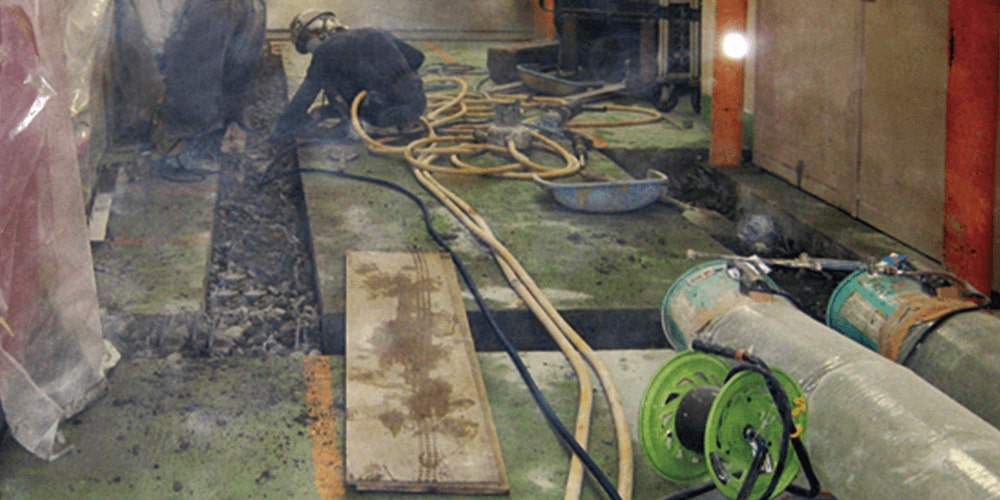 工場内排水溝改修工事の作業中の作業員