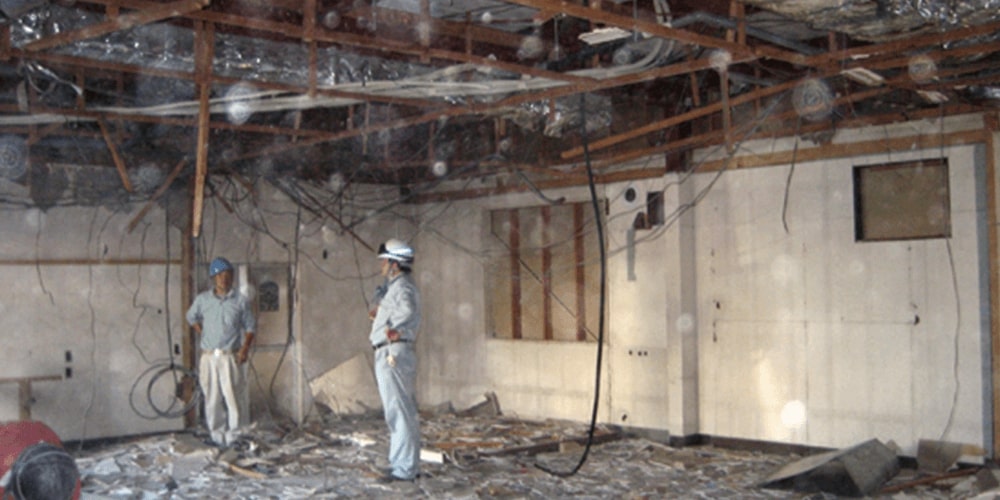 店舗の中を取り壊して作業員が二人立っている