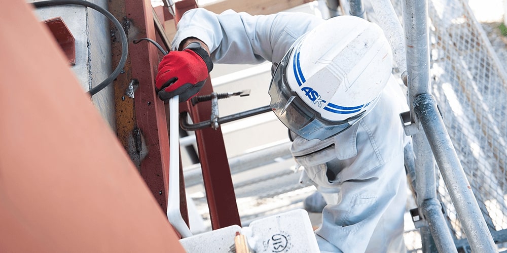 作業員が防具をきて作業をしている写真