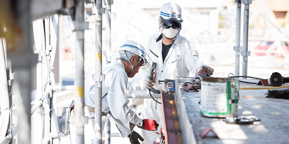 作業員が防具をきて作業をしている写真