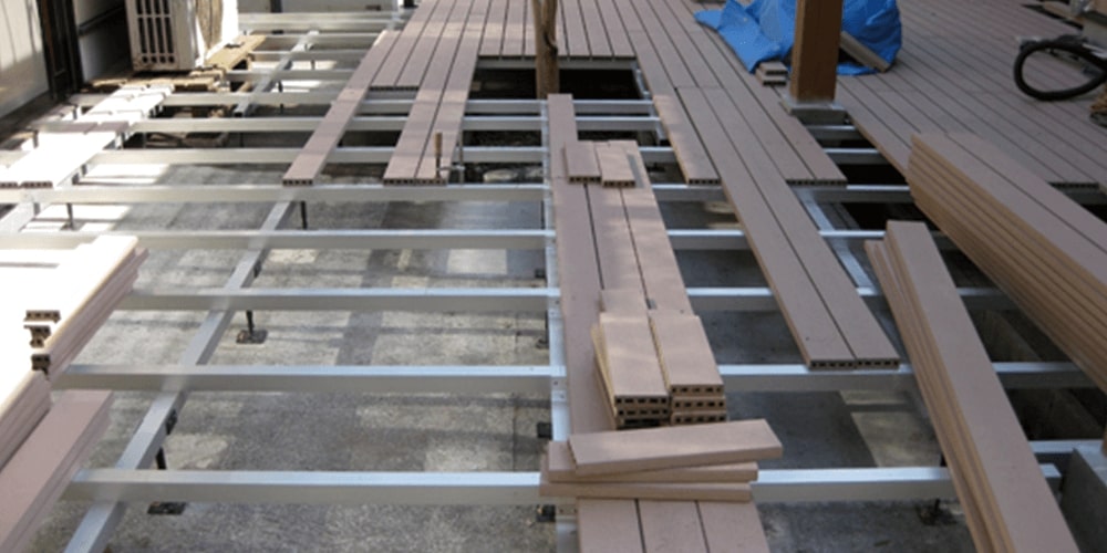 ウッドデッキの中の鉄と木を釘でくっつけている社業員